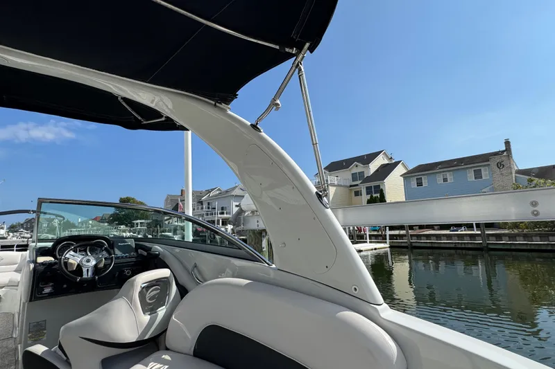 Slide: The Image of 2015 Crownline 285 SS boat interior with waterfront view, featuring sleek design and comfortable seating. - 65