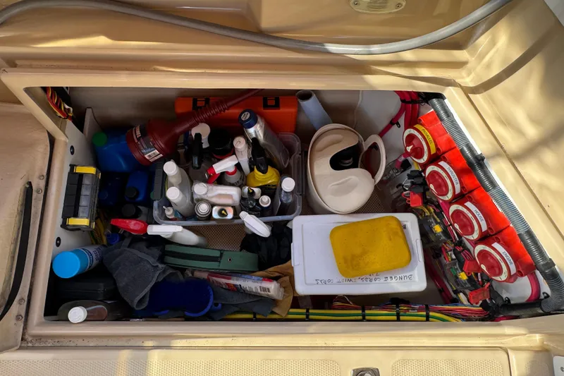Slide: The Image of Storage compartment of 2016 Ranger Tugs R-25SC filled with various tools and supplies. - 15