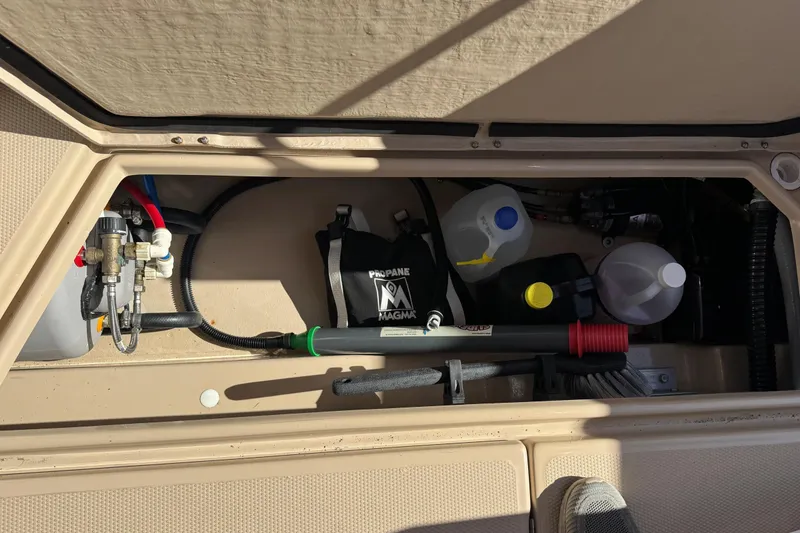 Slide: The Image of 2016 Ranger Tugs R-25SC engine compartment with various components and storage. - 16