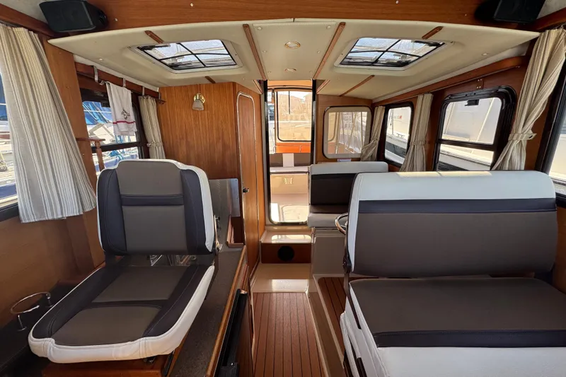 Slide: The Image of Interior of 2016 Ranger Tugs R-25SC boat with seating and wood accents. - 17