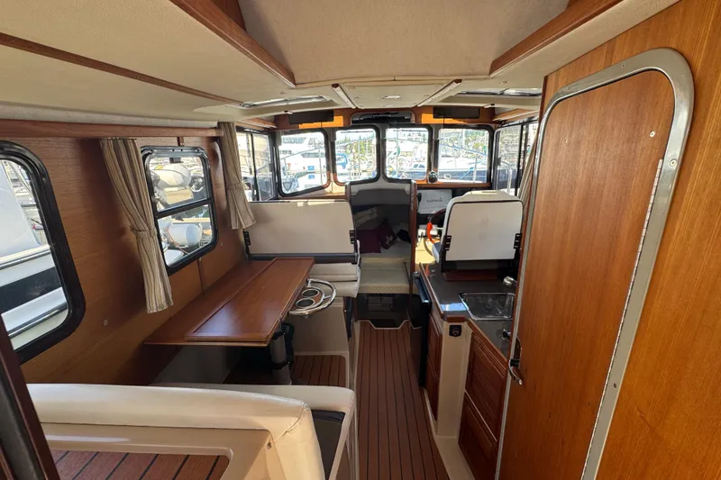 Slide: The Image of Interior of 2016 Ranger Tugs R-25SC boat with wood finishes and seating area. - 19