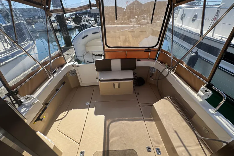 Slide: The Image of 2016 Ranger Tugs R-25SC boat interior with seating, docked at marina. - 20