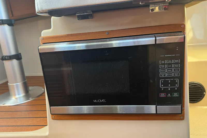 Slide: The Image of Microwave oven inside 2016 Ranger Tugs R-25SC boat, featuring wood accents and control panel. - 22