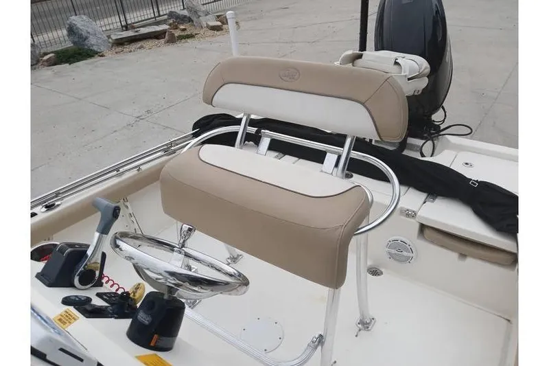 Slide: The Image of 2015 Key West 210 Bay Reef boat interior with beige seating and steering console. - 11