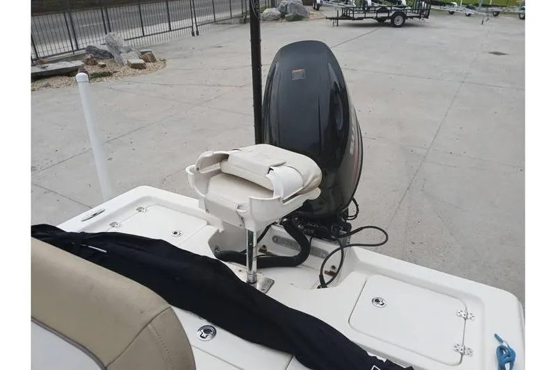 Slide: The Image of 2015 Key West 210 Bay Reef boat with motor and seating, parked on concrete. - 12