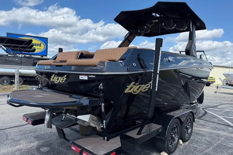 Slide: The Image of 2026 Tigé Z3 boat with sleek black design and tan seating, parked on a trailer. - 5