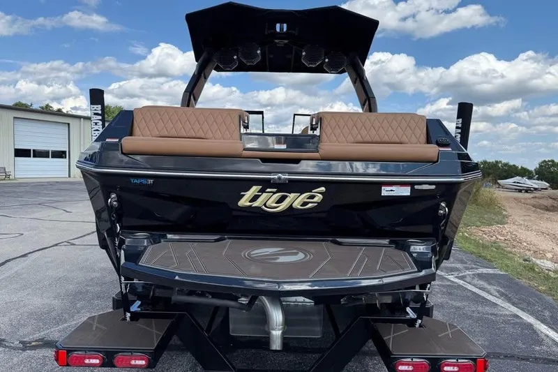 Slide: The Image of 2026 Tigé Z3 boat with brown seating, black exterior, and TAPS 3T system, parked outdoors. - 7