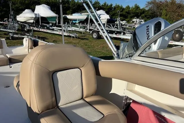 Slide: The Image of 2019 Key West 239 DFS boat interior with tan seating and Honda outboard motor. - 11