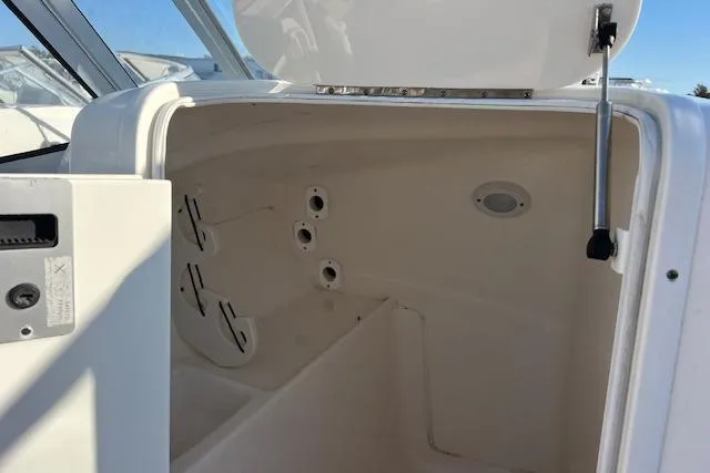 Slide: The Image of 2019 Key West 239 DFS boat storage compartment with open hatch and rod holders. - 9