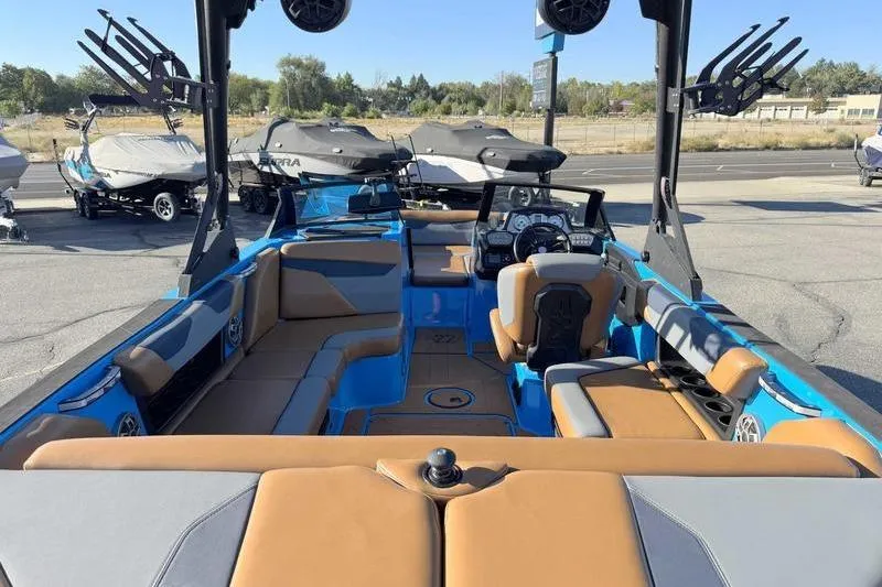Slide: The Image of 2021 Axis A22 boat interior with tan and blue seating, parked outdoors. - 3