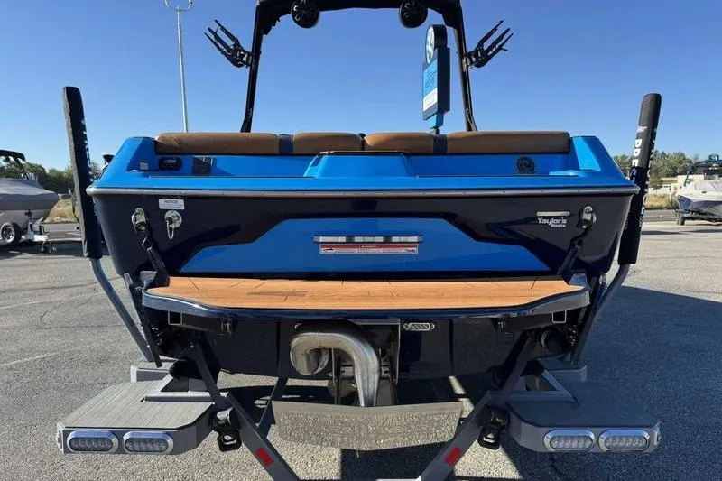 Slide: The Image of 2021 Axis A22 boat rear view with blue and black design, parked outdoors. - 5