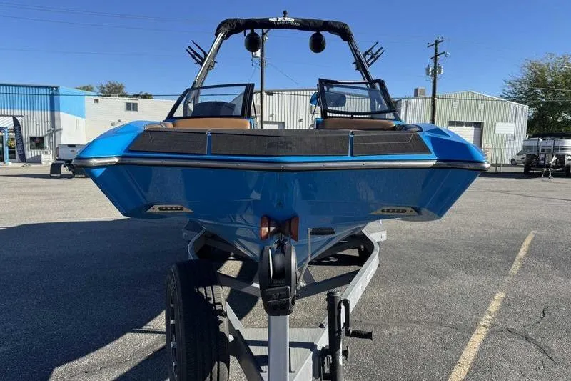 Slide: The Image of 2021 Axis A22 boat in blue on a trailer, parked in an industrial area. - 9