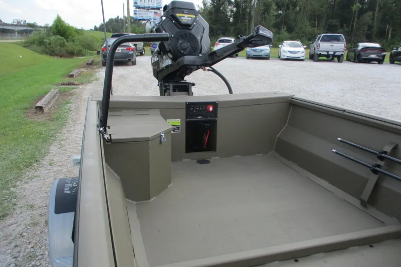 Slide: The Image of 2026 Gator Tail 1748 GATOR boat interior with motor, parked on gravel lot. - 8