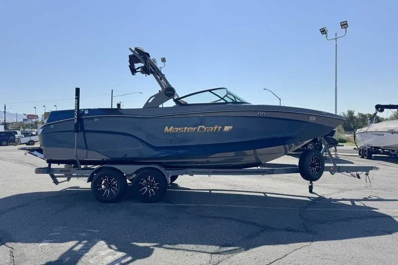 Slide: The Image of 2026 MasterCraft XT22 boat on trailer in parking lot, side view. - 10