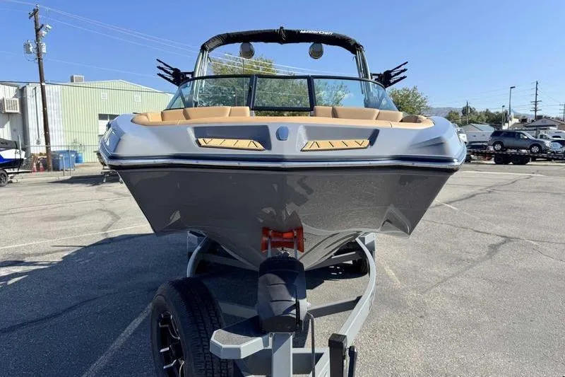 Slide: The Image of 2026 MasterCraft XT22 boat on trailer, parked outdoors under clear blue sky. - 3