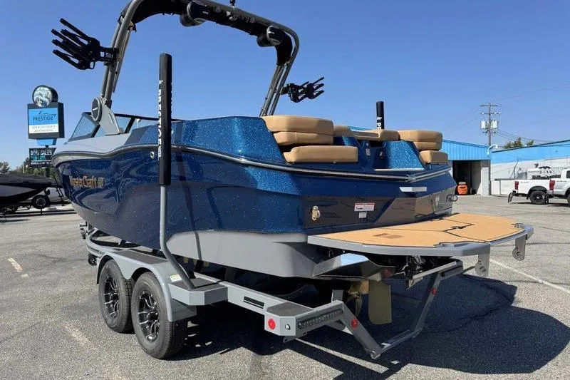 Slide: The Image of 2026 MasterCraft XT22 boat on trailer, blue exterior, parked outdoors. - 6
