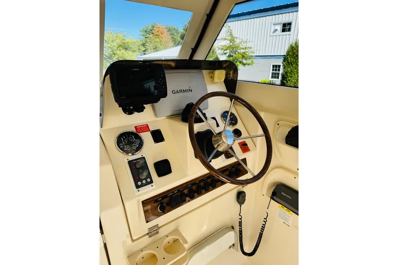 Slide: The Image of 2006 Mainship Pilot 30 Sedan helm with Garmin navigation, steering wheel, and control panel. - 10