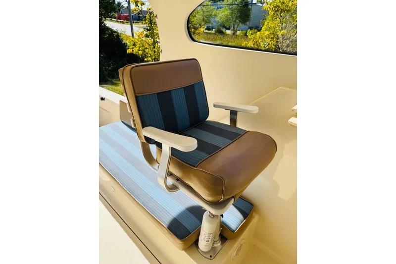 Slide: The Image of Captain's chair on 2006 Mainship Pilot 30 Sedan boat, featuring blue and brown upholstery. - 16