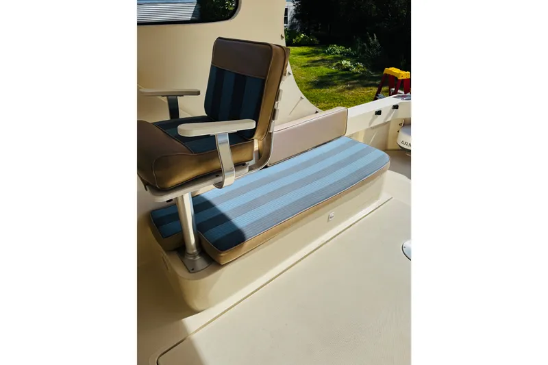 Slide: The Image of 2006 Mainship Pilot 30 Sedan interior with striped seating and armchair. - 17