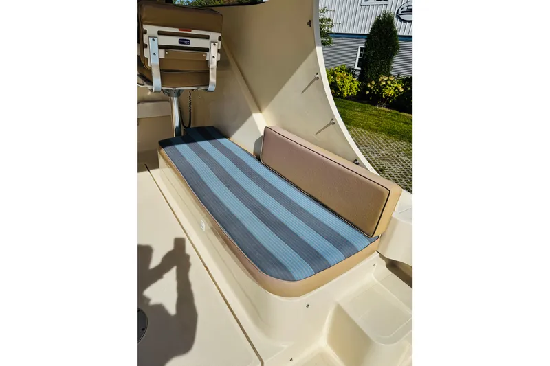 Slide: The Image of 2006 Mainship Pilot 30 Sedan interior with striped seating and helm chair. - 18