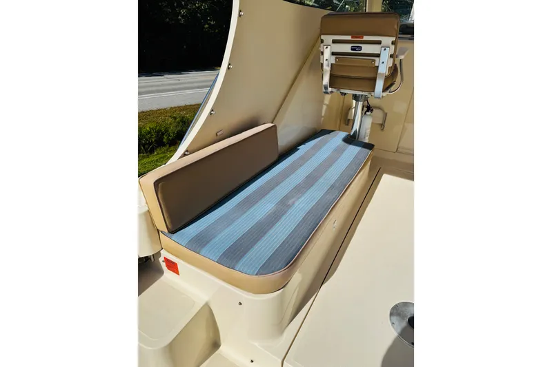 Slide: The Image of 2006 Mainship Pilot 30 Sedan interior with cushioned seating and helm chair. - 19