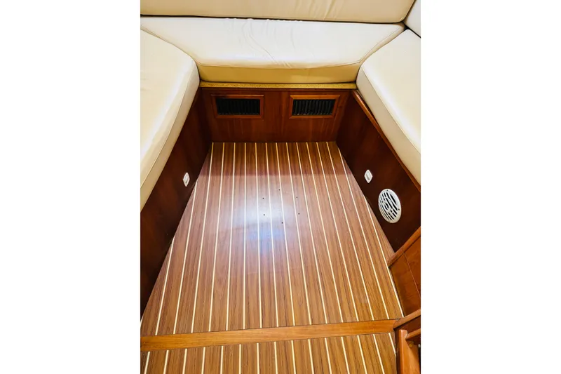 Slide: The Image of 2006 Mainship Pilot 30 Sedan interior with wood flooring and cushioned seating. - 3