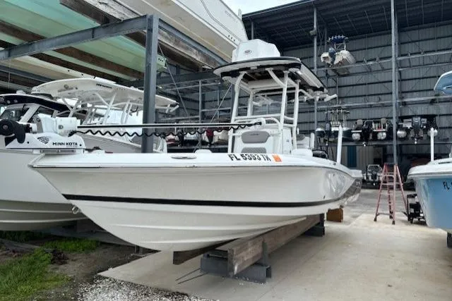 The Image of 2023 Caymas 26 HB boat in storage, featuring a sleek white design. - 1