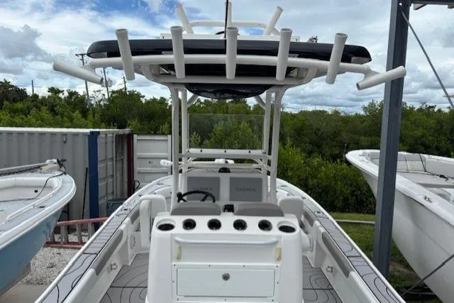 Slide: The Image of 2023 Caymas 26 HB boat with T-top and rod holders, docked outdoors. - 12
