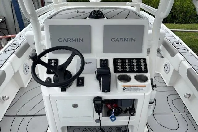Slide: The Image of 2023 Caymas 26 HB boat dashboard with dual Garmin displays and steering wheel. - 14