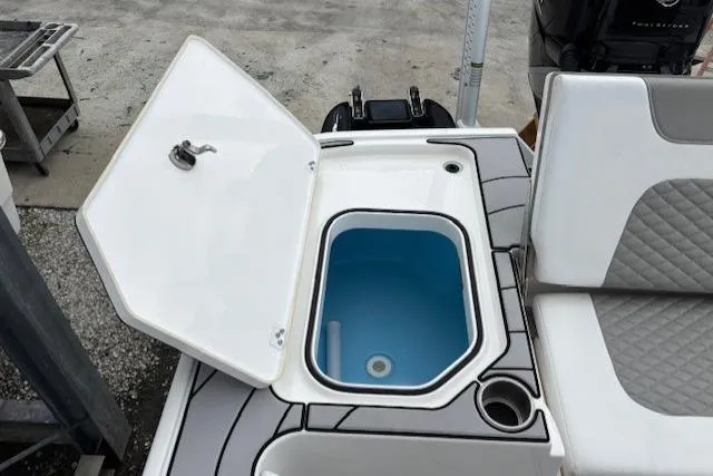 Slide: The Image of 2023 Caymas 26 HB boat with open storage compartment and seating area. - 3