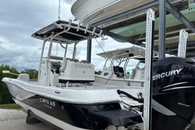 Slide: The Image of 2023 Caymas 26 HB boat with Mercury Verado engine, docked under a cloudy sky. - 7