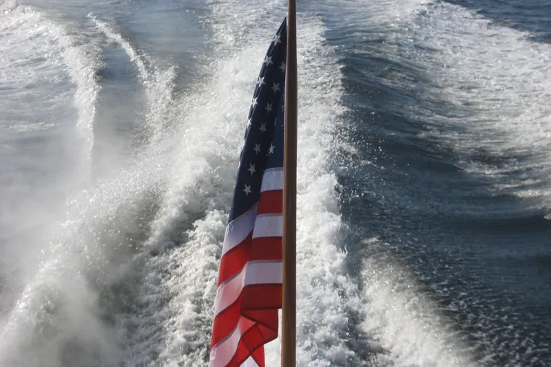 Slide: The Image of American flag on 2007 Legacy Yachts 32, with ocean wake in the background. - 10
