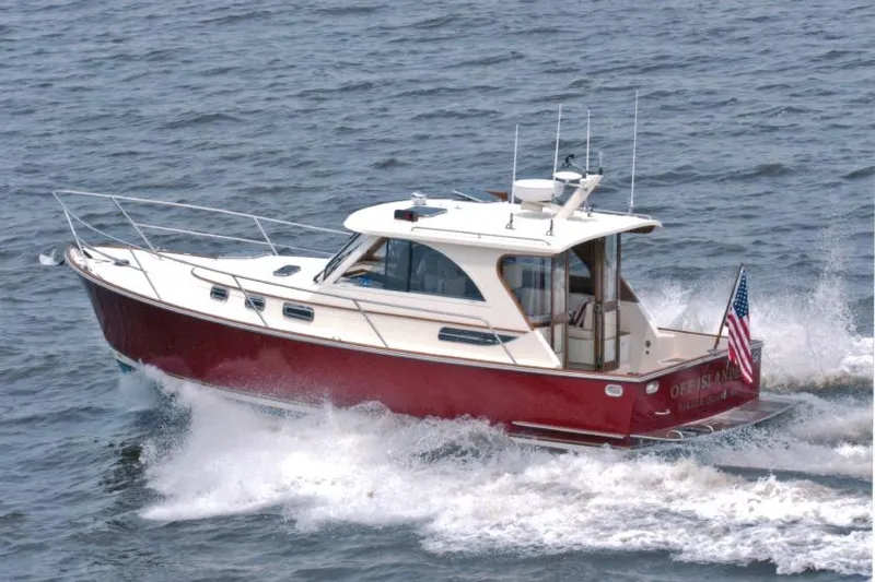 Slide: The Image of 2007 Legacy Yachts 32 cruising on open water, displaying American flag. - 2