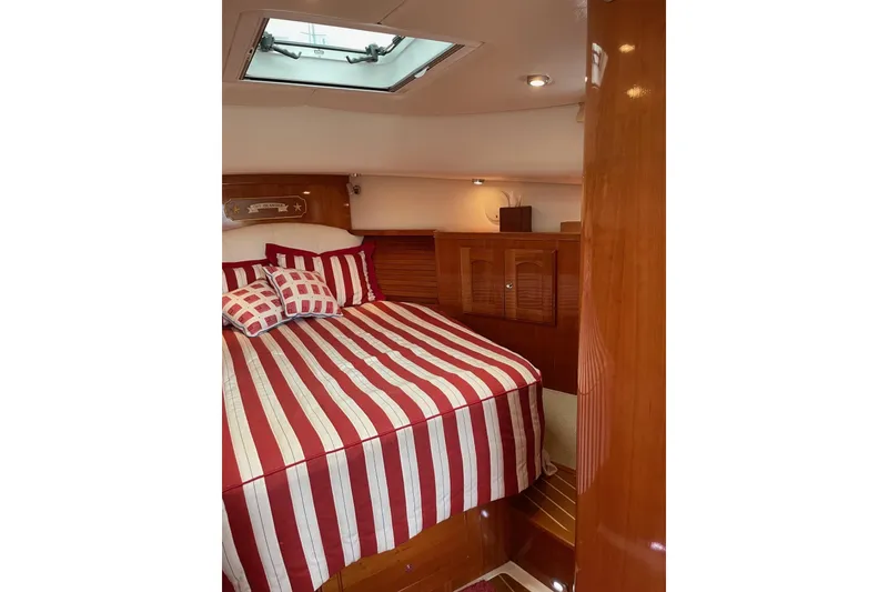 Slide: The Image of Cozy cabin interior of 2007 Legacy Yachts 32 with striped bedding and wooden finishes. - 23
