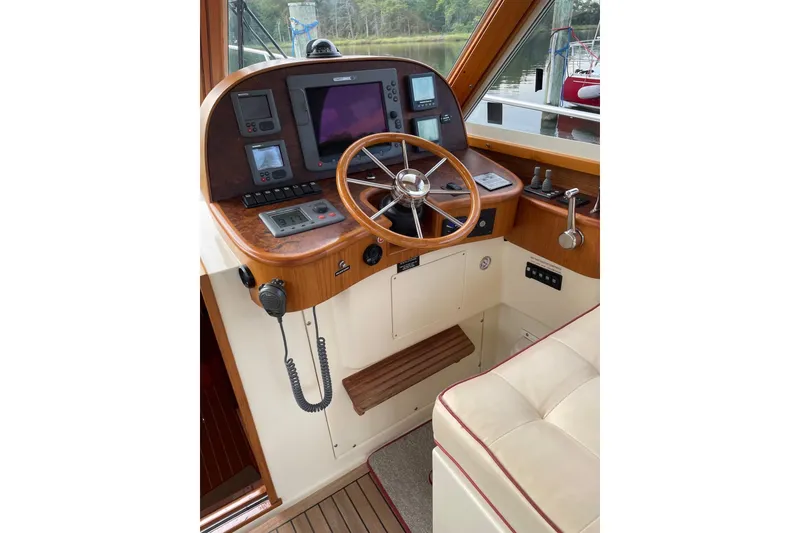 Slide: The Image of 2007 Legacy Yachts 32 helm with wooden steering wheel and navigation instruments. - 24