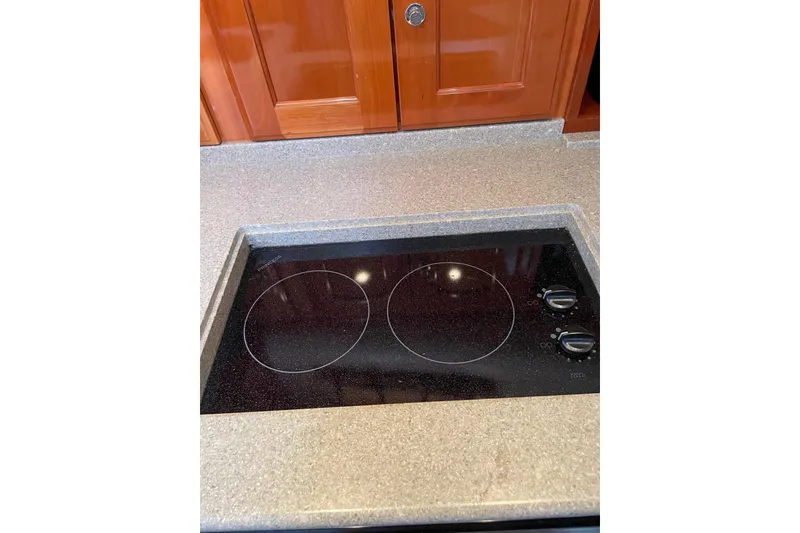 Slide: The Image of Stovetop in 2007 Legacy Yachts 32 galley with wooden cabinetry. - 28