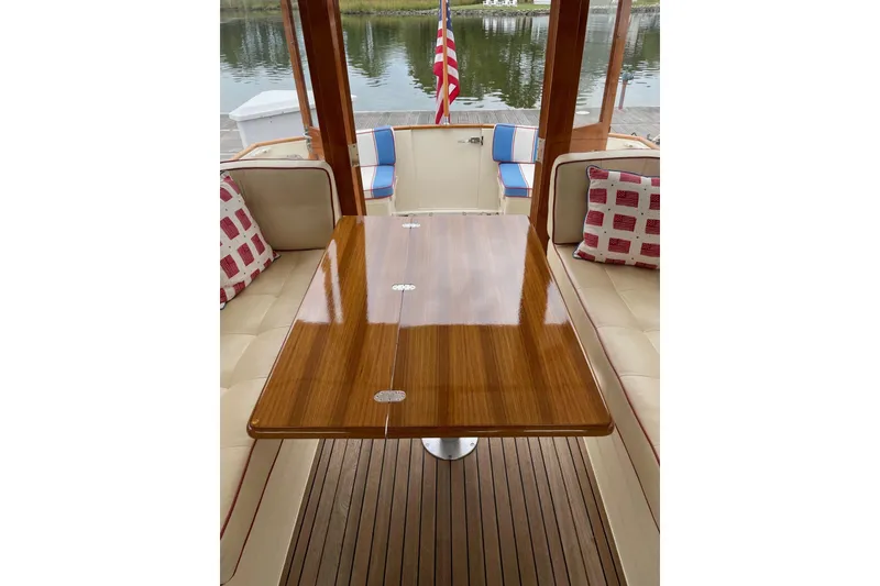 Slide: The Image of Interior of 2007 Legacy Yachts 32 with polished wood table and cushioned seating. - 34
