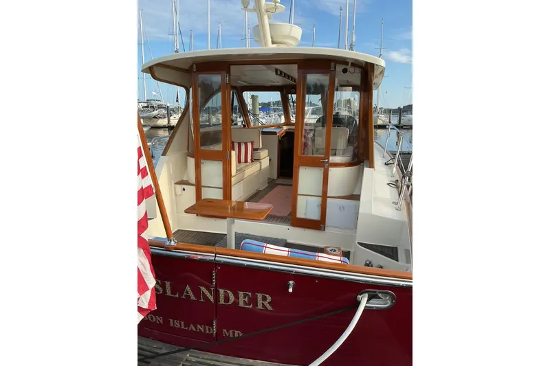 Slide: The Image of 2007 Legacy Yachts 32 docked, featuring wooden doors and American flag. - 5