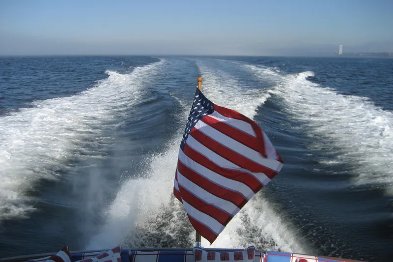 Slide: The Image of American flag on 2007 Legacy Yachts 32, cruising with ocean wake in background. - 9