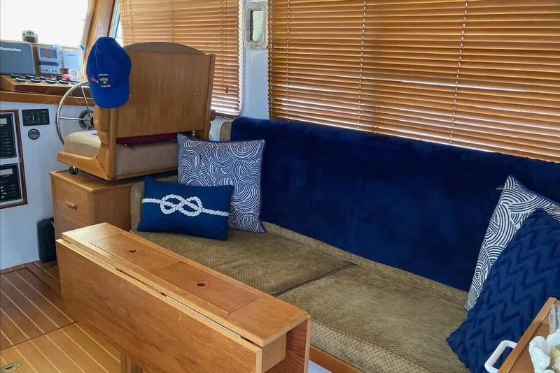 Slide: The Image of Interior of a 1993 Flye Point 31 boat with blue cushions and wooden blinds. - 10