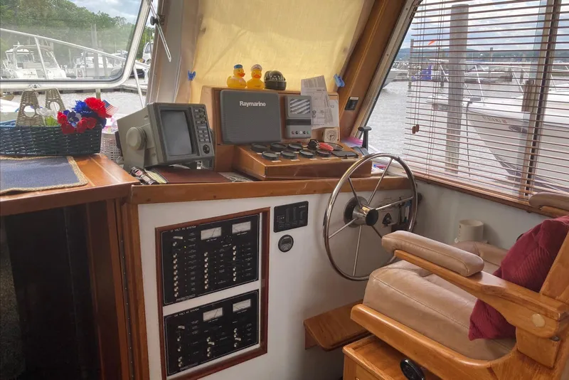 Slide: The Image of Helm of 1993 Flye Point 31 boat with navigation equipment and cozy seating. - 11