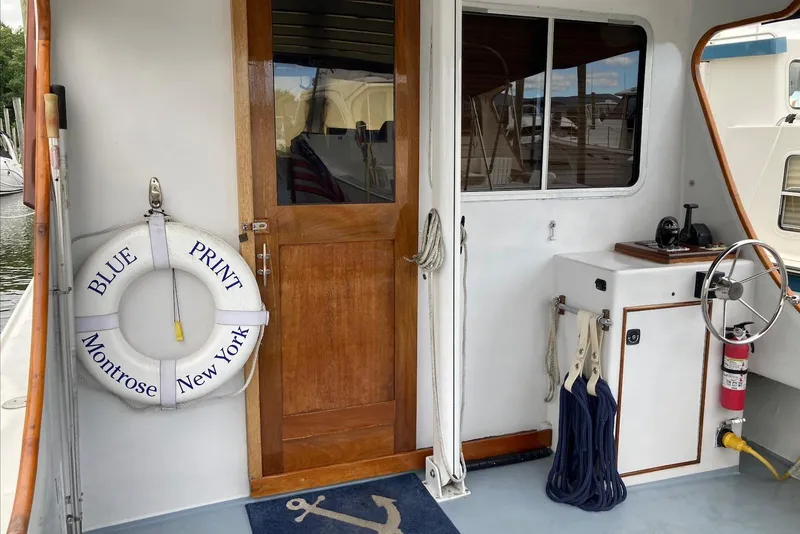 Slide: The Image of Flye Point 31 boat deck with life ring, wooden door, and nautical equipment, 1993 model. - 5