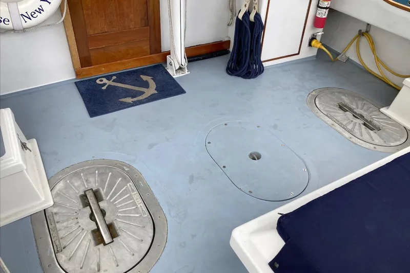 Slide: The Image of Boat deck with anchor mat, hatches, and safety equipment on a 1993 Flye Point 31. - 6