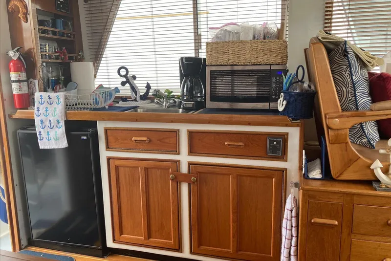 Slide: The Image of Cozy boat kitchen with wooden cabinets, microwave, coffee maker, and nautical decor. Flye Point 31, 1993. - 8
