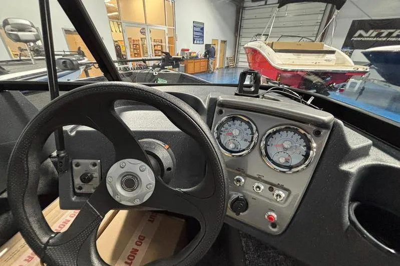Slide: The Image of 2026 Tracker Pro Guide V-16 WT dashboard with steering wheel and gauges in a showroom. - 7