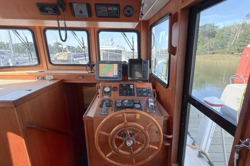 Slide: The Image of 1999 Nordic Tug 37 helm with wooden steering wheel and navigation equipment. - 15