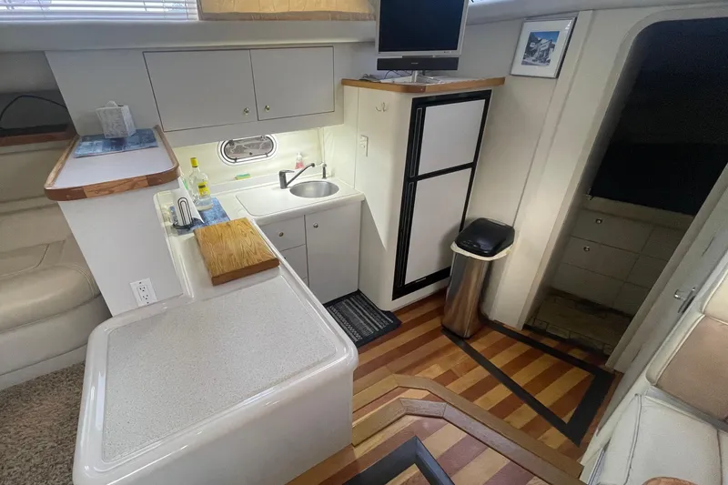 Slide: The Image of 1997 Cruisers Yachts 3650 Aft Cabin interior with kitchenette and wood flooring. - 21