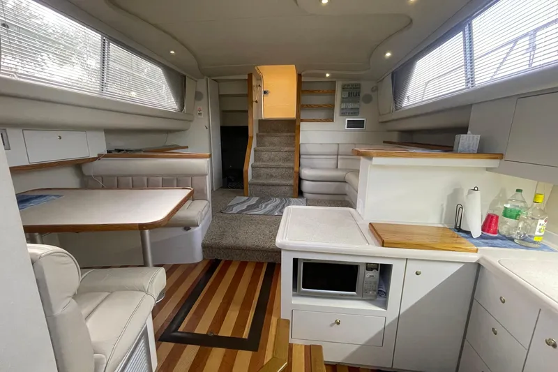 Slide: The Image of 1997 Cruisers Yachts 3650 Aft Cabin interior with kitchen, dining area, and stairs. - 23