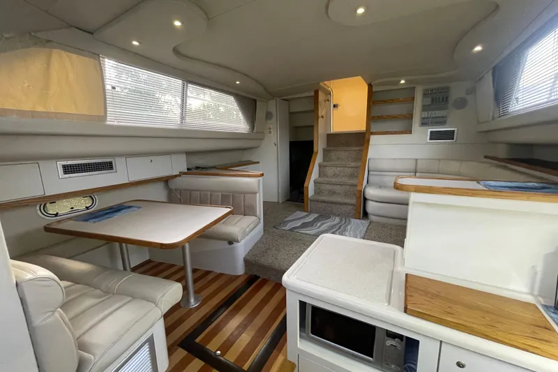 Slide: The Image of 1997 Cruisers Yachts 3650 Aft Cabin interior with dining area and stairs, featuring modern design. - 27