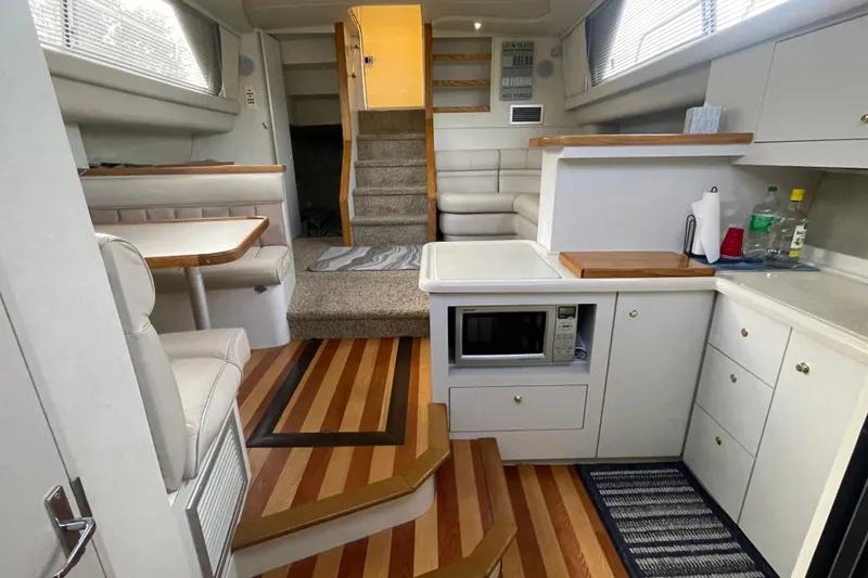 Slide: The Image of 1997 Cruisers Yachts 3650 Aft Cabin interior with kitchen, dining area, and stairs. - 28